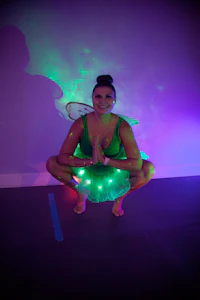 a woman in a green fairy costume crouching down