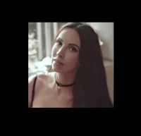 a woman in a black dress is posing for the camera