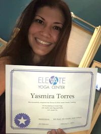 yasmina torres is holding up a certificate from the elevator yoga center